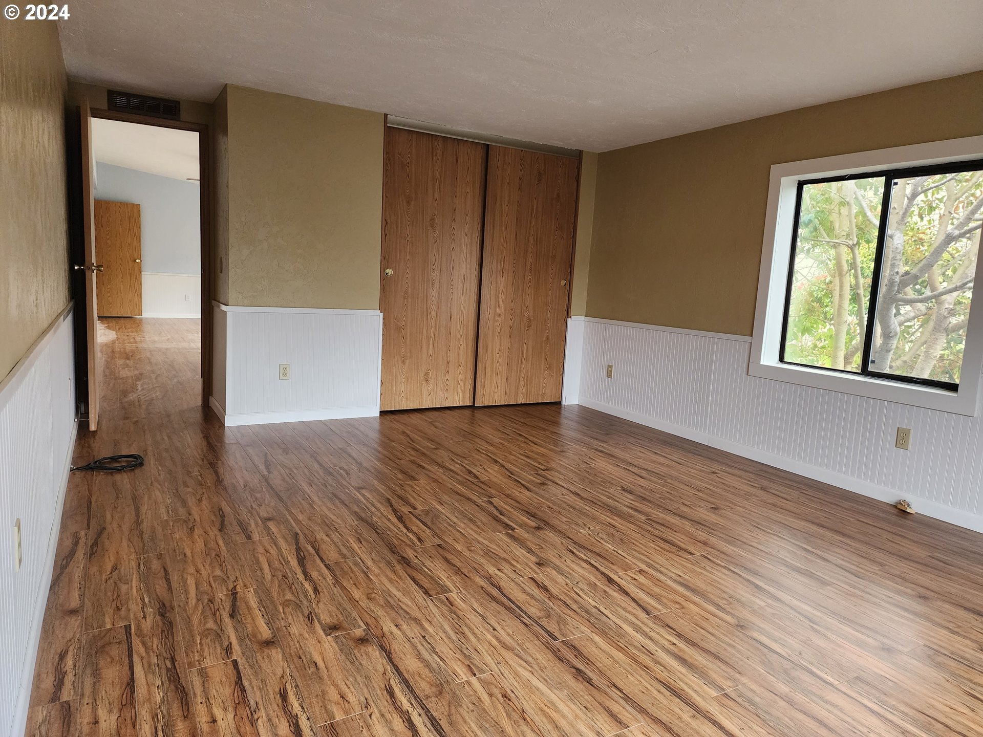 100 River Bend Road, Unit 127 Reedsport, OR 97467 - Photo 7 of 21 an empty room with wooden floor and windows