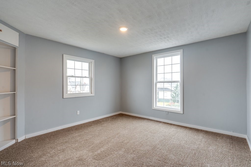 1607 9th Street Southwest Canton, OH 44706 - Photo 24 of 41 Carpeted room with two multi-pane windows, a recessed ceiling light, and built-in white shelving