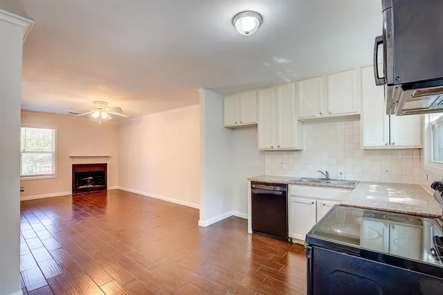 a kitchen with granite countertop a sink cabinets and wooden floor