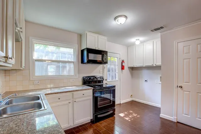 a kitchen with a sink cabinets and a window