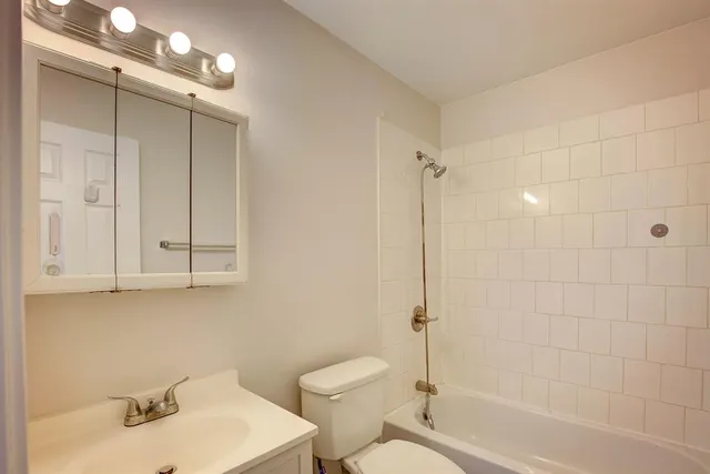 a bathroom with a toilet sink vanity and shower