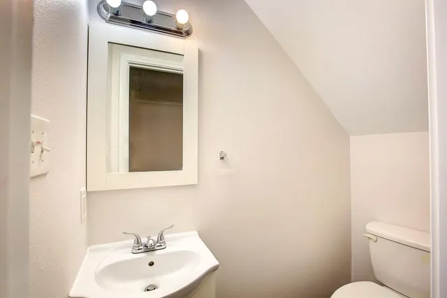 a bathroom with a toilet sink and mirror