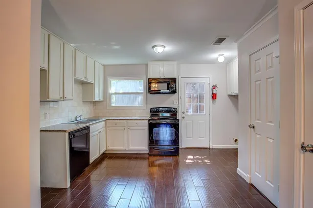 a kitchen with granite countertop a refrigerator stove top oven and sink