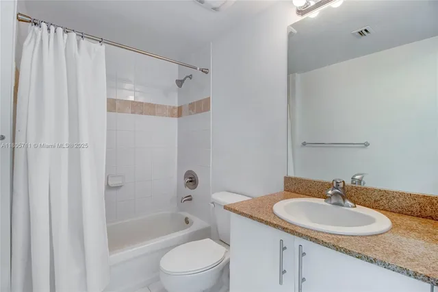 a bathroom with a granite countertop sink a toilet and shower