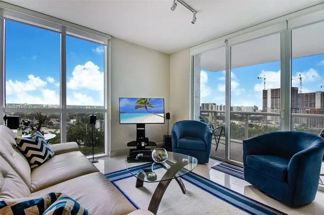 a living room with furniture city view and large windows