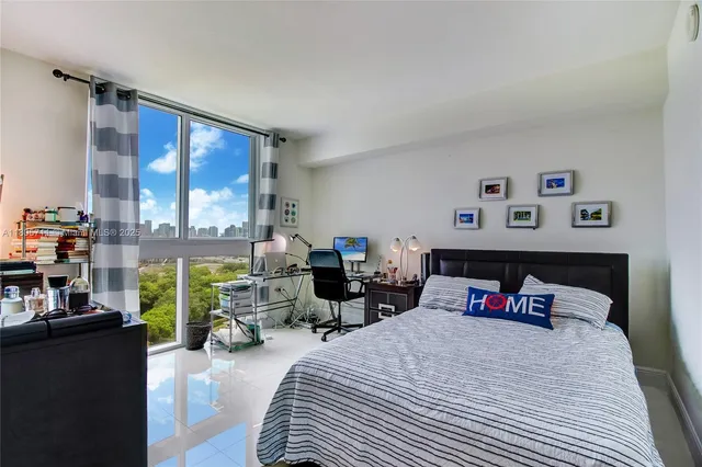 a bedroom with furniture and a large window