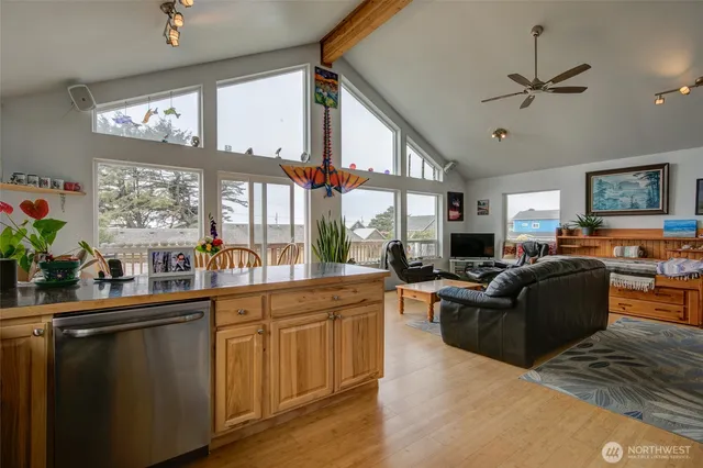 a living room with furniture kitchen view and a large window