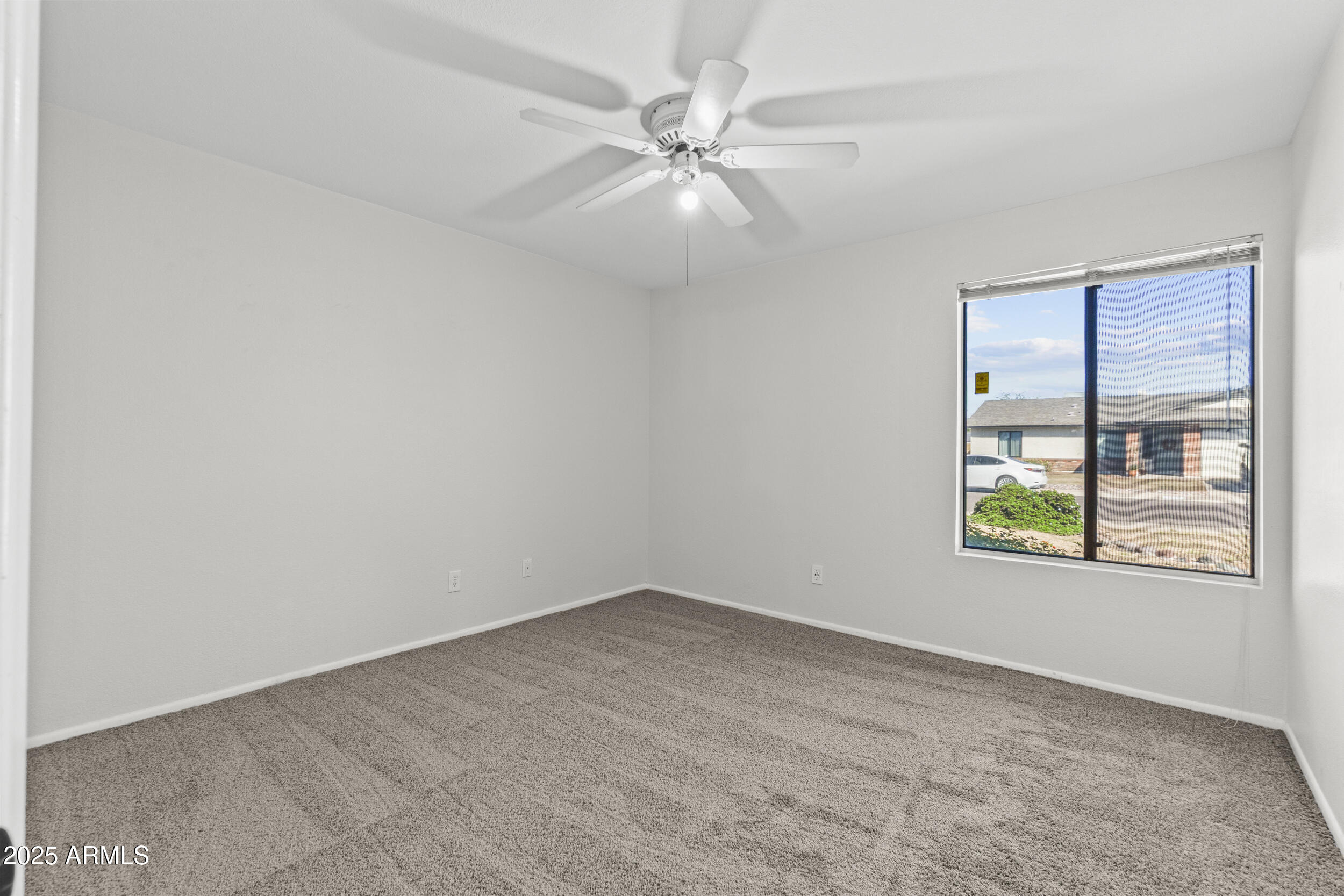 4119 West St John Road Glendale, AZ 85308 - Photo 22 of 29 an empty room with windows and fan