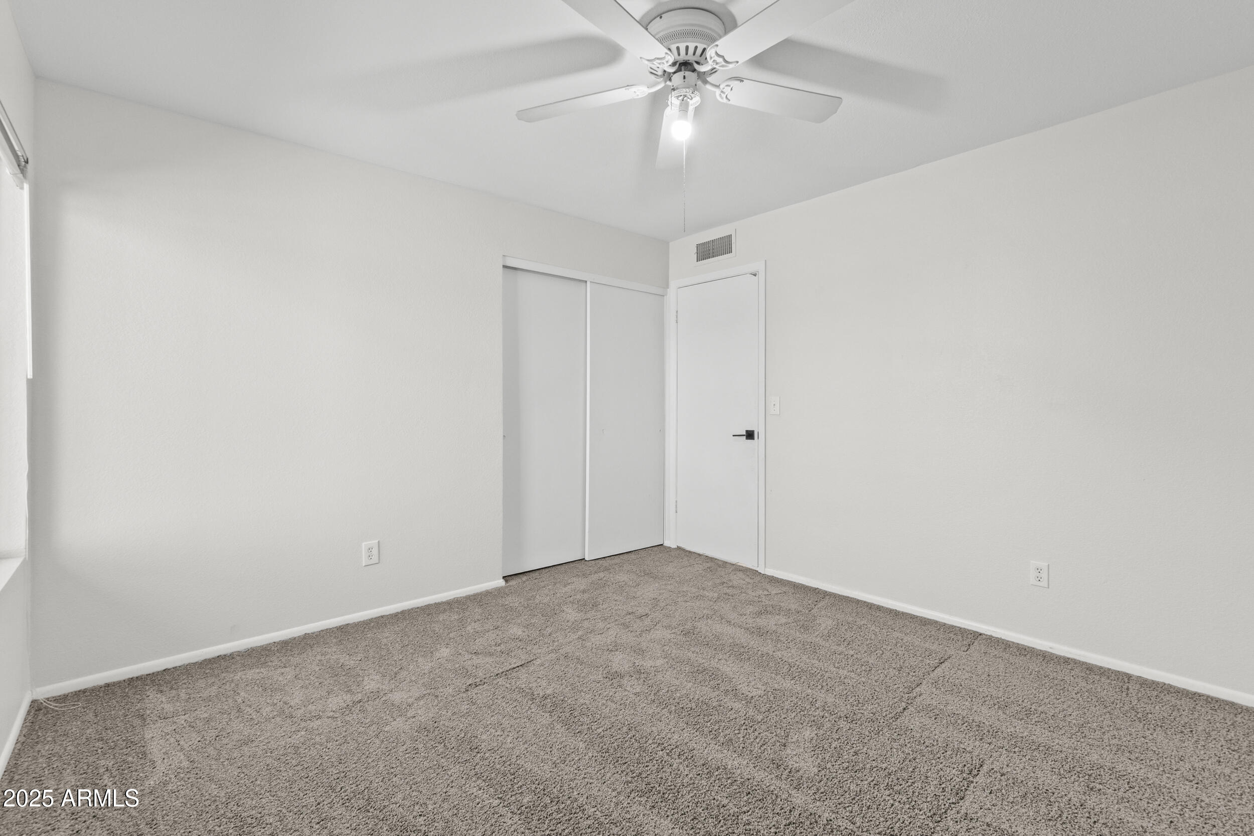 4119 West St John Road Glendale, AZ 85308 - Photo 23 of 29 an empty room with a window and a fan