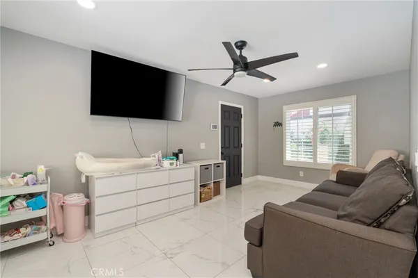 a living room with furniture and a ceiling fan