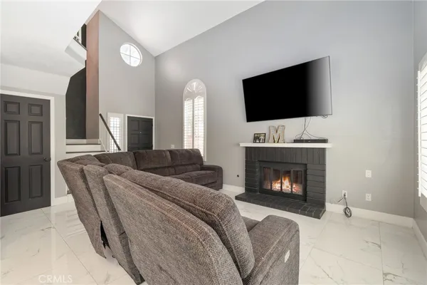 a living room with furniture a flat screen tv and a fireplace