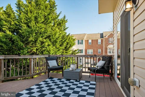 a roof deck with wooden floor and outdoor seating