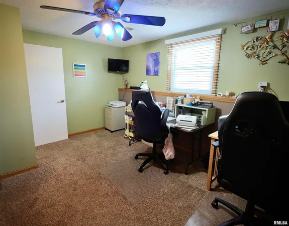 a view of a workspace with furniture and a window