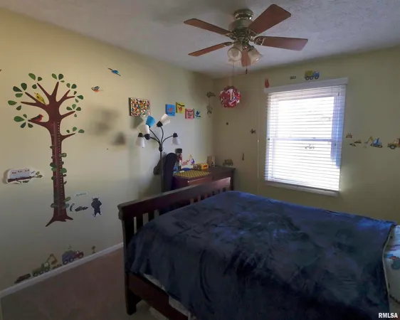 a bed sitting in a bedroom next to a window