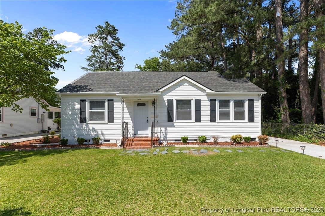a front view of a house with a garden and trees