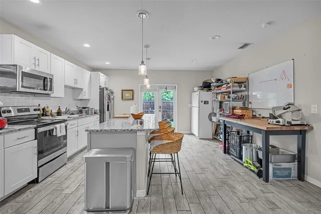 a kitchen with white cabinets and appliances