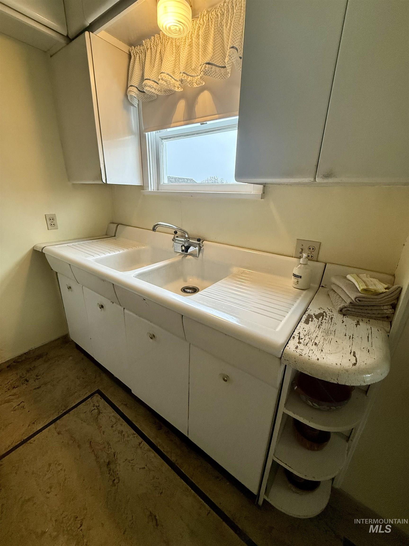 1368 Chestnut Street Clarkston, WA 99403 - Photo 8 of 25 Kitchen featuring white cabinets, concrete flooring, and light countertops