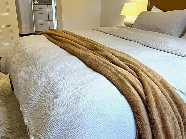 a bedroom with a bed and painting on the wall