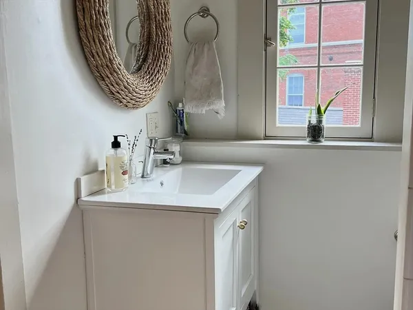 a bathroom with a sink a mirror and a window
