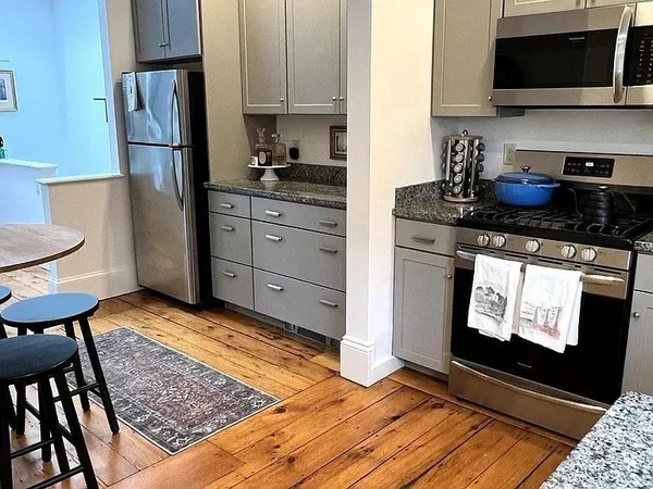 a kitchen with stainless steel appliances granite countertop a refrigerator stove top oven and sink