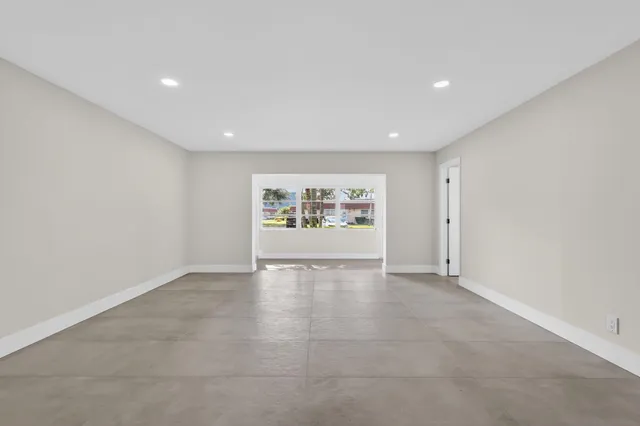 a view of empty room with kitchen