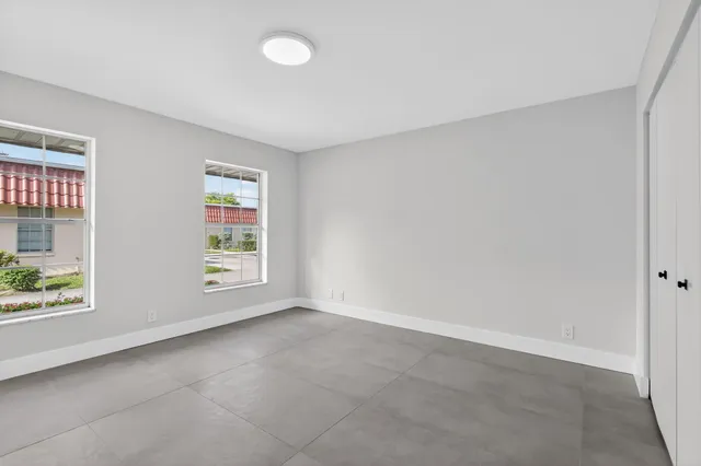 a bedroom with a bed and a potted plant next to a window