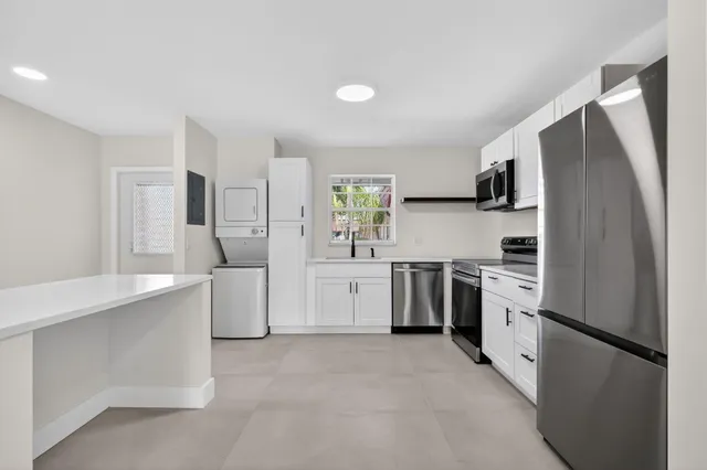 a kitchen with white cabinets and white appliances