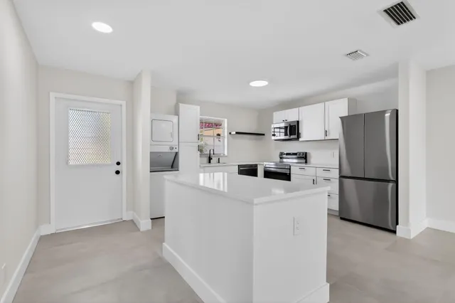 a view of kitchen with refrigerator and stove