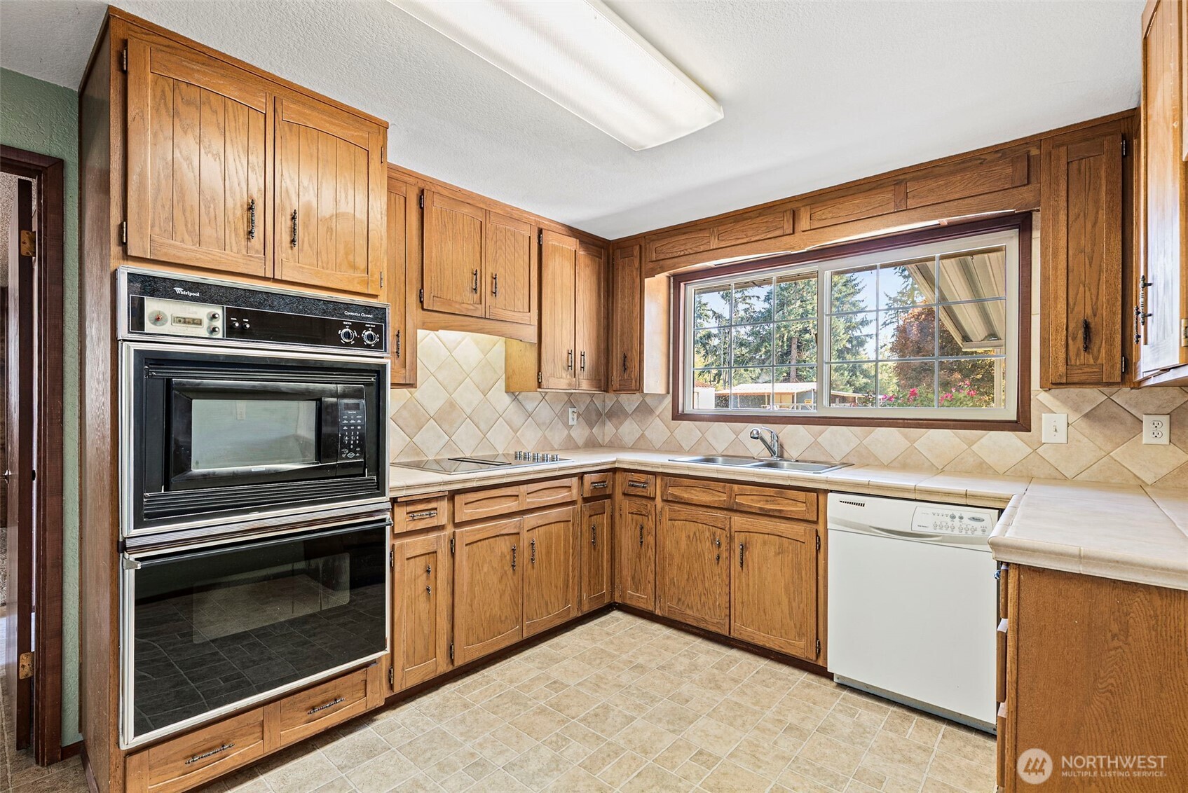 8112 266th Street East Graham, WA 98338 - Photo 7 of 40 a kitchen with granite countertop stainless steel appliances a stove sink and microwave