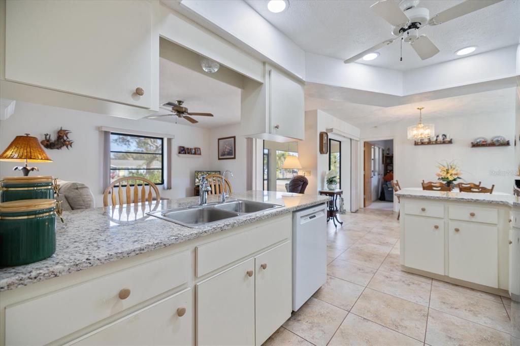 420 Duke Road Venice, FL 34293 - Photo 11 of 31 a large kitchen with granite countertop a sink and white cabinets