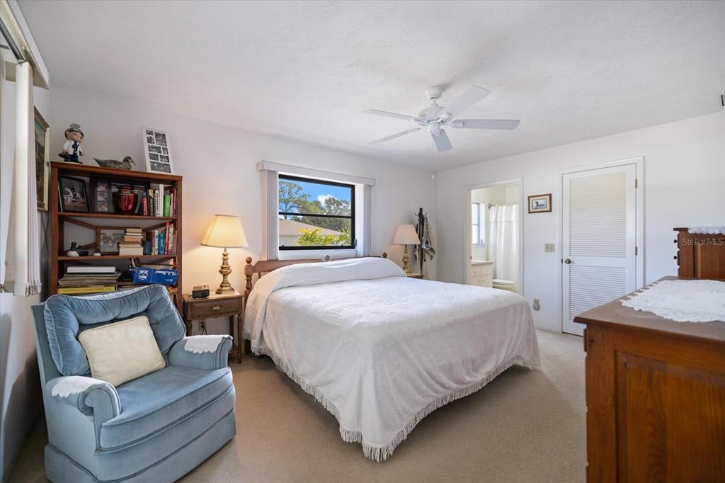 420 Duke Road Venice, FL 34293 - Photo 17 of 31 a spacious bedroom with a bed a couch and a book shelf