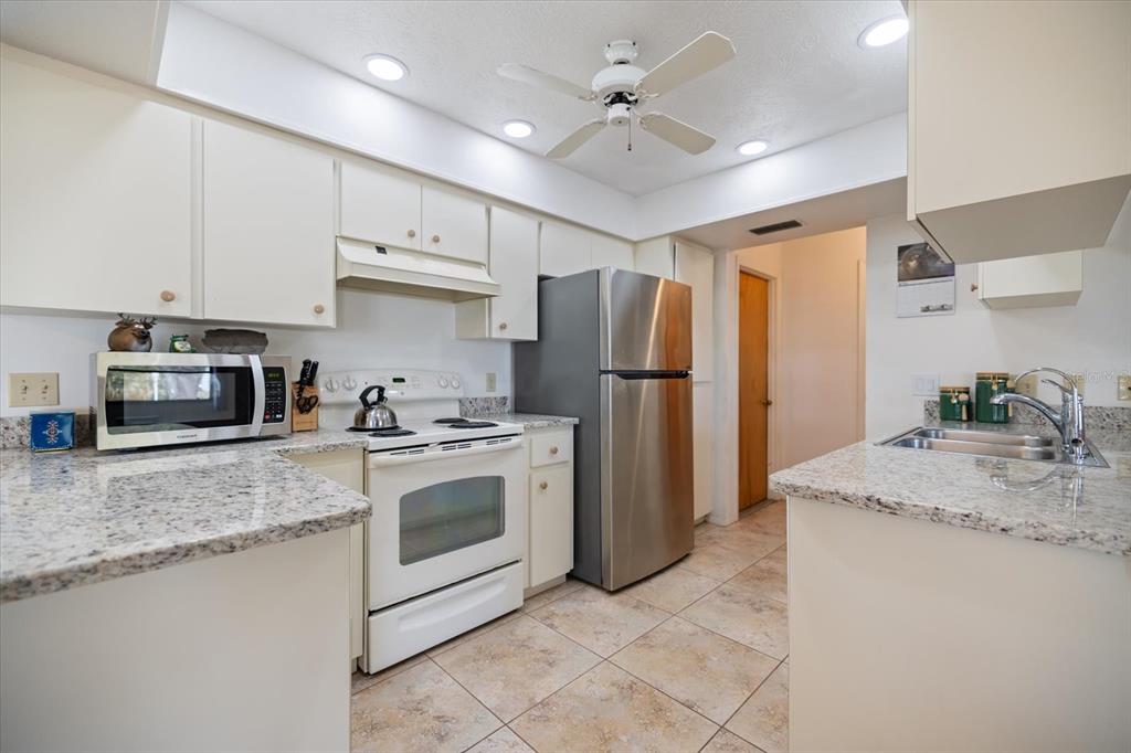 420 Duke Road Venice, FL 34293 - Photo 2 of 31 a kitchen with stainless steel appliances granite countertop a refrigerator a stove a sink and a microwave
