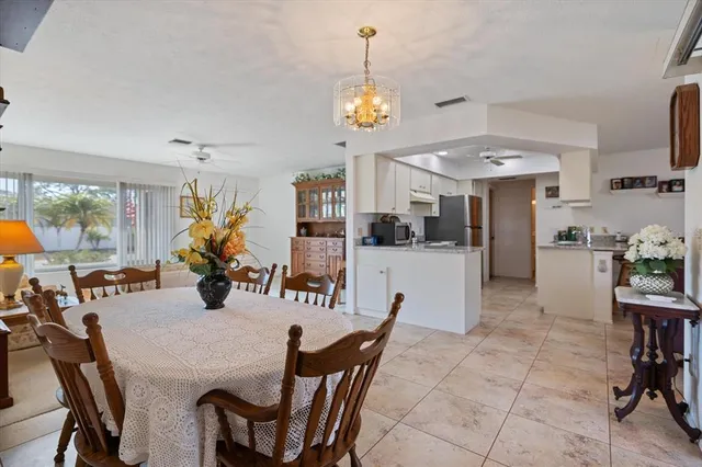a view of a dining room and livingroom with furniture wooden floor a chandelier