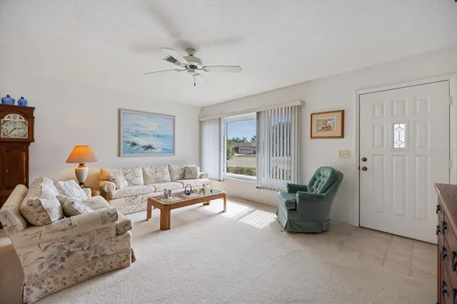 a view of a white house with a yard and palm trees