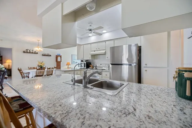 a living room with furniture a chandelier fan and a window