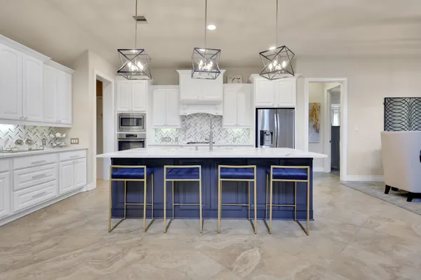 a kitchen with kitchen island granite countertop a table and chairs in it