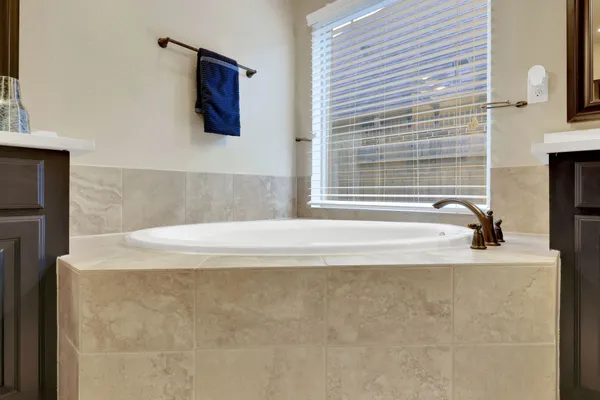 a bathroom with a tub sink and mirror