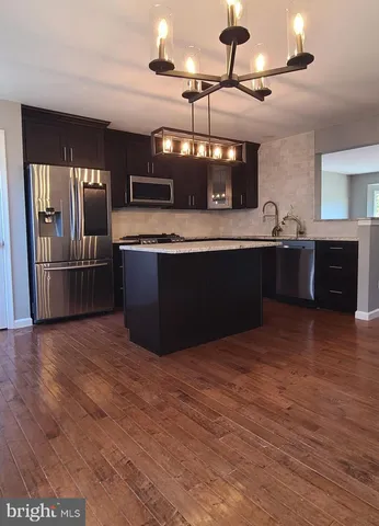 a large kitchen with stainless steel appliances kitchen island granite countertop a large counter top and stove