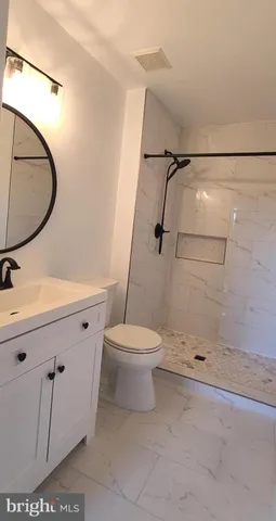 a bathroom with a sink a toilet and a mirror