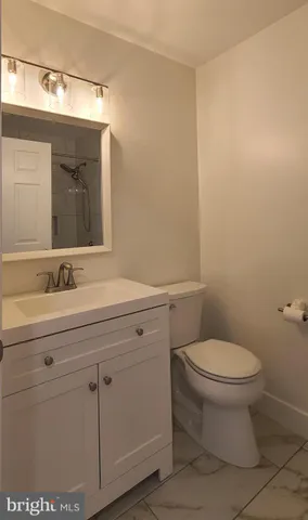 a bathroom with a toilet a sink and mirror