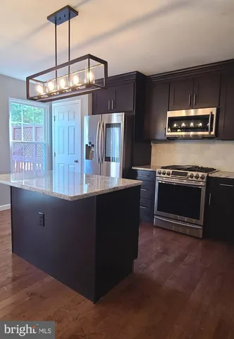 a kitchen with kitchen island granite countertop a stove and cabinets