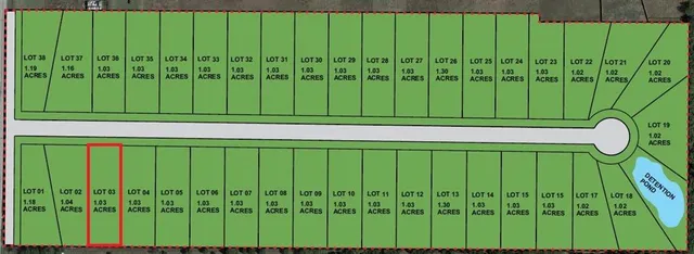 a green field with lots of trees in the background