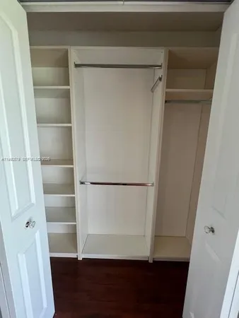 a view of walk in closet with empty racks