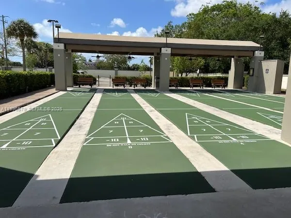 a view of a tennis ground with large trees