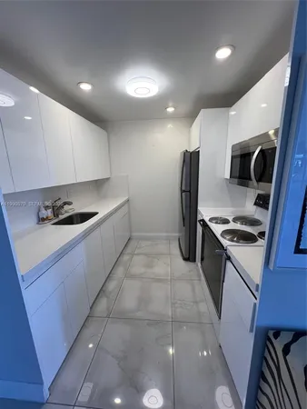 a kitchen with a sink cabinets and stainless steel appliances