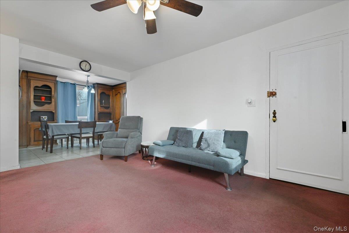 218-03 68th Avenue, Unit 1 Queens, NY 11364 - Photo 3 of 13 Carpeted living area featuring ceiling fan