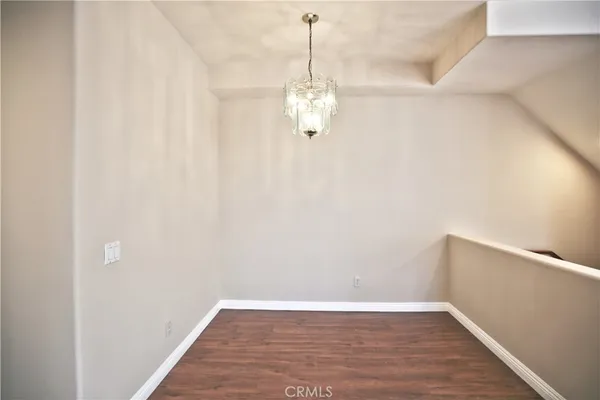 a view of a room with wooden floor and ceiling fan