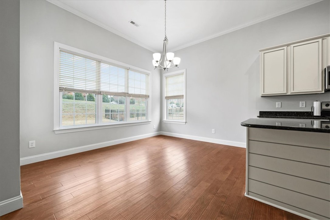 102 Ripplestone Way Anderson, SC 29621 - Photo 11 of 39 Natural light floods this dining area, featuring lustrous hardwood flooring and crown molding.