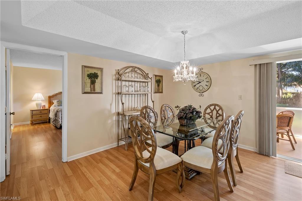 817 Teryl Road, Unit 1 Naples, FL 34112 - Photo 12 of 47 a view of a dining room with furniture wooden floor and chandelier