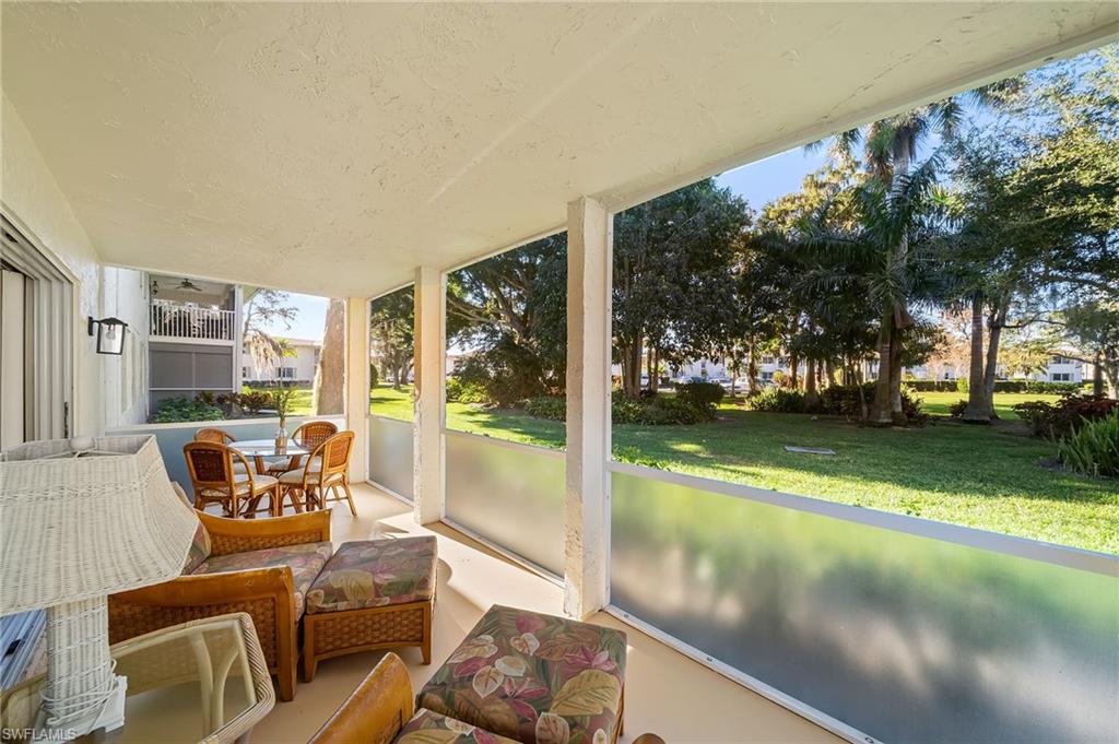 817 Teryl Road, Unit 1 Naples, FL 34112 - Photo 27 of 47 a living room with yard and a large tree